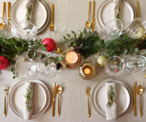 table-festive-avec-vaisselle-doree-et-décor-végétal